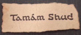 A small torn scrap of printed paper reading Tamám Shud