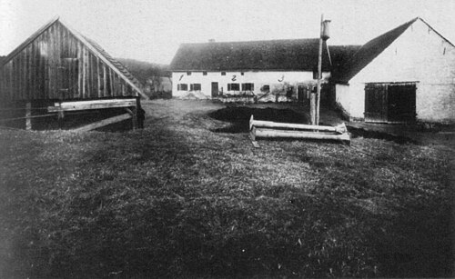 An old photograph of a remote farmhouse and barn in the Bavarian countryside